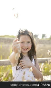 Girl at the park playing with flower spike in summertime