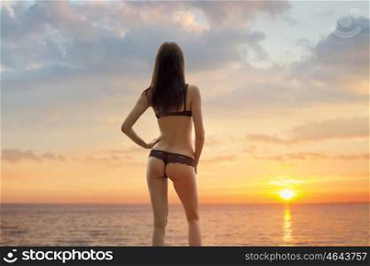 girl at the sea in a bathing suit at sunset. girl at the sea