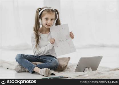girl attending virtual classes holding drawing