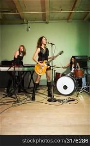 Girl band playing their instruments.