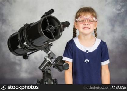 Girl bespectacled amateur astronomer funny smiling standing by telescope
