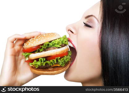 girl biting hamburger with widely opened mouth on white background