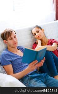 Girl boring while her boyfriend reading book&#xA;