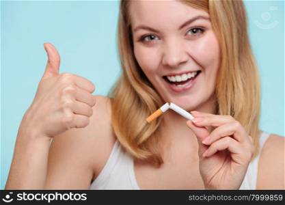 Girl break down cigarette.. Smilling pretty girl breake down cigarette. Winning with addicted nicotine problems in young age giving thumb up gesture. Quitting from addiction concept.