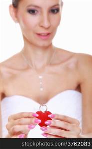 Girl bride in white dress showing engagement or wedding ring in red heart shaped box isolated on white background.