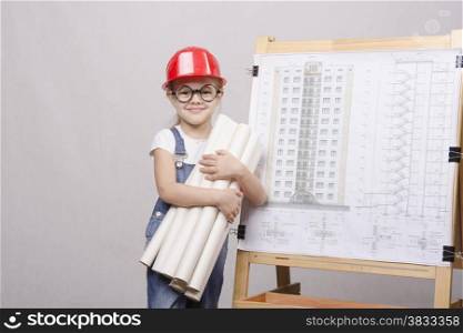 Girl Builder, architect, holding a bunch of drawings, standing at the blackboard with the drawing of the building