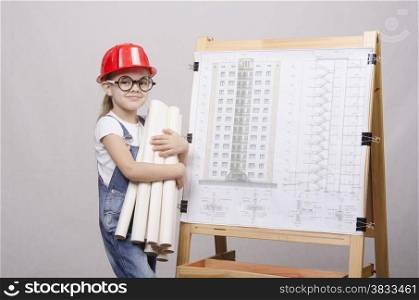 Girl Builder, architect, holding a bunch of drawings, standing at the blackboard with the drawing of the building