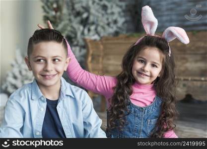 girl bunny ears making horns with fingers boy