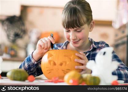 Girl Carving Halloween Lantern From Pumpkin At Home