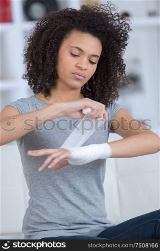 girl changing her bandage on the wrist