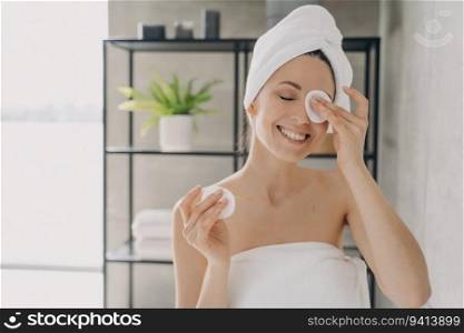 Girl cleanses skin, attractive woman with towel after bathing. Happy woman showers at home. Delicate skin care, purifying.