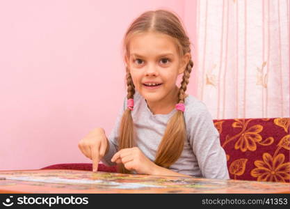 Girl collects a picture of the puzzle, and looked into the frame