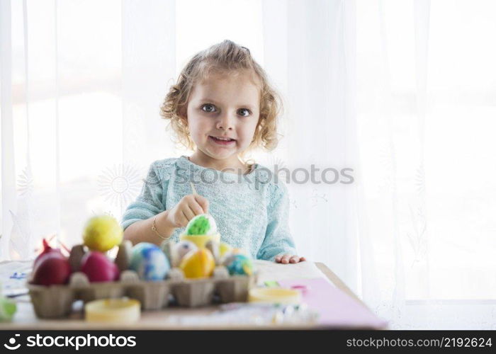 girl coloring eggs looking camera