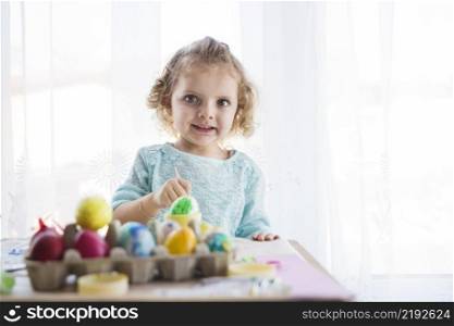 girl coloring eggs looking camera