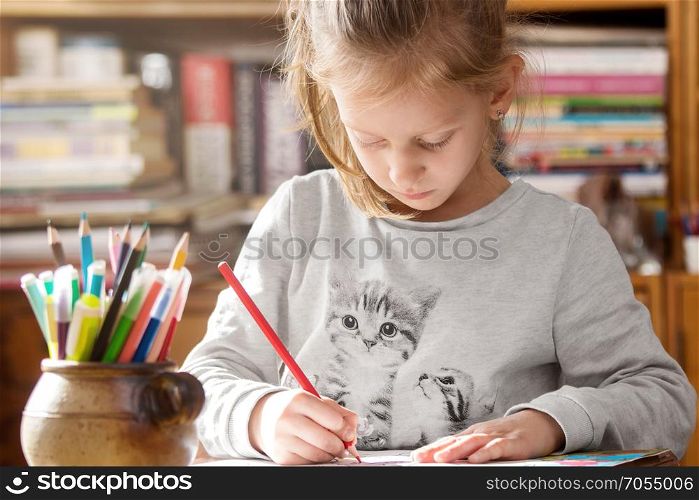Girl coloring on paper having creative time at home