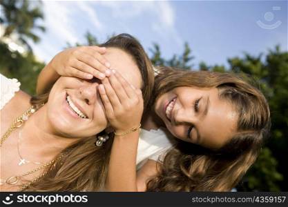 Girl covering her mother&acute;s eyes