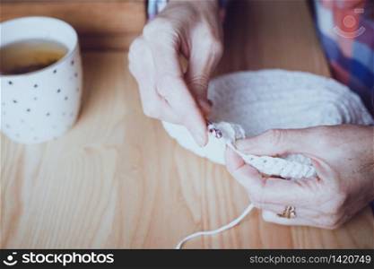 girl crocheting a rug. Woman knits crochet. Home comfort and hobby. Needlework