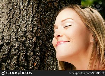 Girl cuddling a tree and dreaming - a metaphor for environmentalism