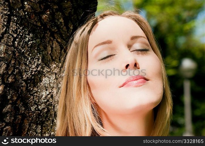 Girl cuddling a tree and dreaming - a metaphor for environmentalism
