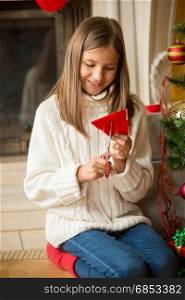 Girl cutting paper snowflakes for decorations on Christmas