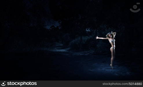 Girl dancing in dark. Young girl in white swim wear dancing in night