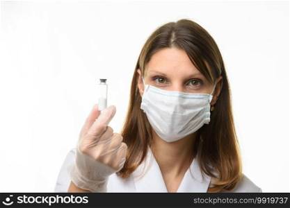 Girl doctor holding a glass tube with white powder in her hands