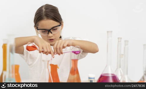 girl doing chemistry experiments with safety glasses
