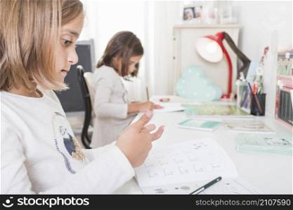 girl doing homework near sister