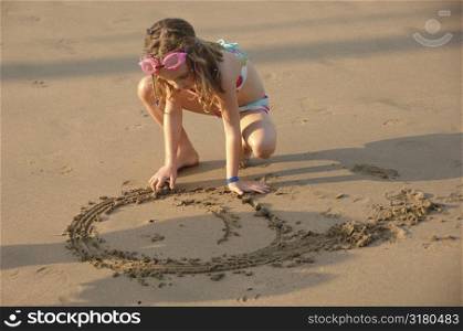 Girl drawing in sand