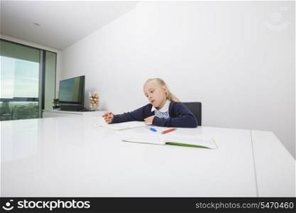 Girl drawing on paper at table