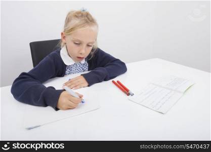 Girl drawing on paper with felt tip pen at table