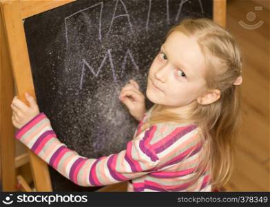 Girl draws on an easel in the nursery