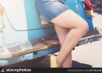 Girl dressed in jeans skirt stay at car, closeup