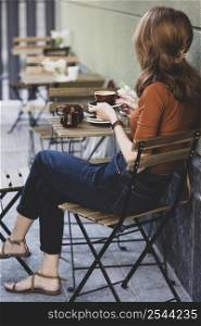 girl drinking coffee on the outdoor terrace in a cafe