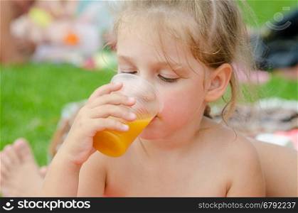 Girl drinking fruit juice from a plastic disposable cup