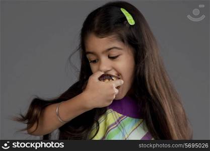 Girl eating a chocolate doughnut