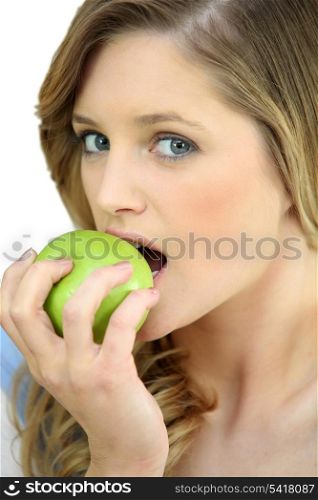 Girl eating a crisp green apple