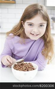 Girl Eating Bowl Of Sugary Breakfast Cereal In Kitchen