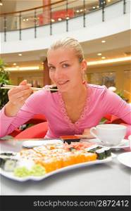 Girl eating sushin in a restaurant
