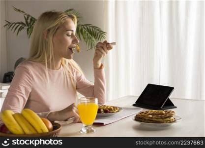 girl eating waffles watching tablet
