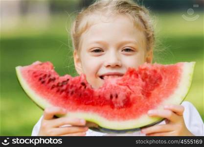 Girl eating watermelon. Cute girl in park eating juicy watermelon