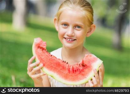 Girl eating watermelon. Cute girl in park eating juicy watermelon