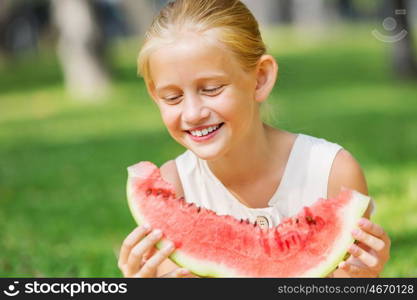 Girl eating watermelon. Cute girl in park eating juicy watermelon