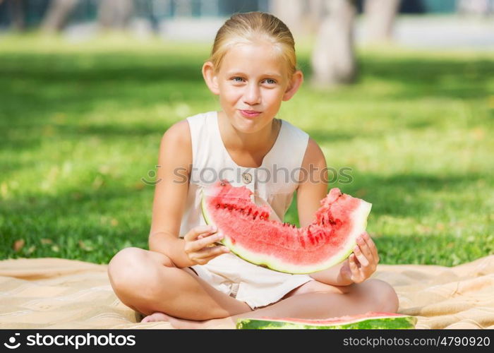 Girl eating watermelon. Cute girl in park eating juicy watermelon