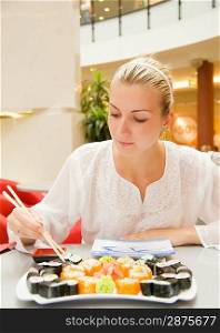 Girl eats sushi in a rastaurant