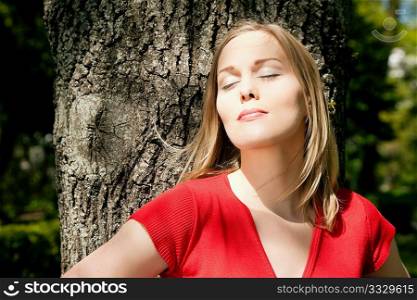 Girl embracing a tree - classic tree hugger picture as a metaphor for conservatism and environmentalism
