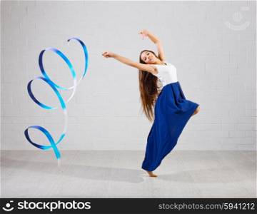 Girl engaged art gymnastic on grey wall