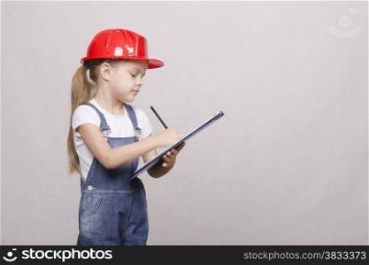 Girl engineer is a helmet folder and writes in folder
