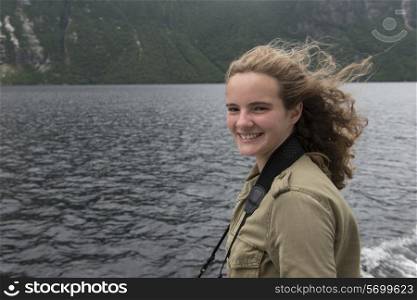 Girl enjoying Western Brook Pond fjord boat tour, Gros Morne National Park, Newfoundland and Labrador, Canada