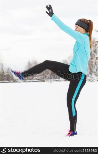 Girl exercising in park, legs stretching exercises. Winter sports, outdoor fitness, fashion, nature workout, health concept.. Winter sport, girl exercising in park